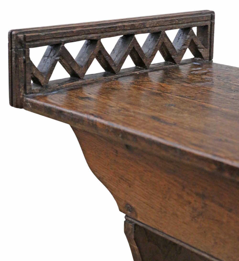 A 19th-century Arts and Crafts oak and elm window seat with pierced geometric gallery ends and solid shaped legs. View III