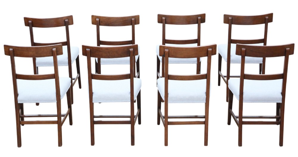 A set of eight 19th-century mahogany dining chairs featuring inlaid decorative top rails and light off-white upholstered seats. View VII