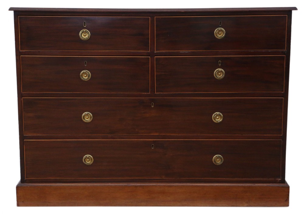 A 19th-century dark mahogany chest of drawers with decorative string inlay, brass ring handles, and a solid plinth base.