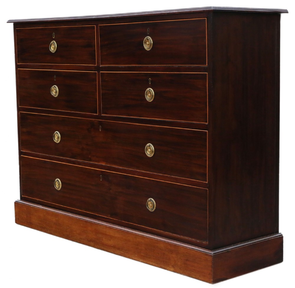 A 19th-century dark mahogany chest of drawers with decorative string inlay, brass ring handles, and a solid plinth base. View IV