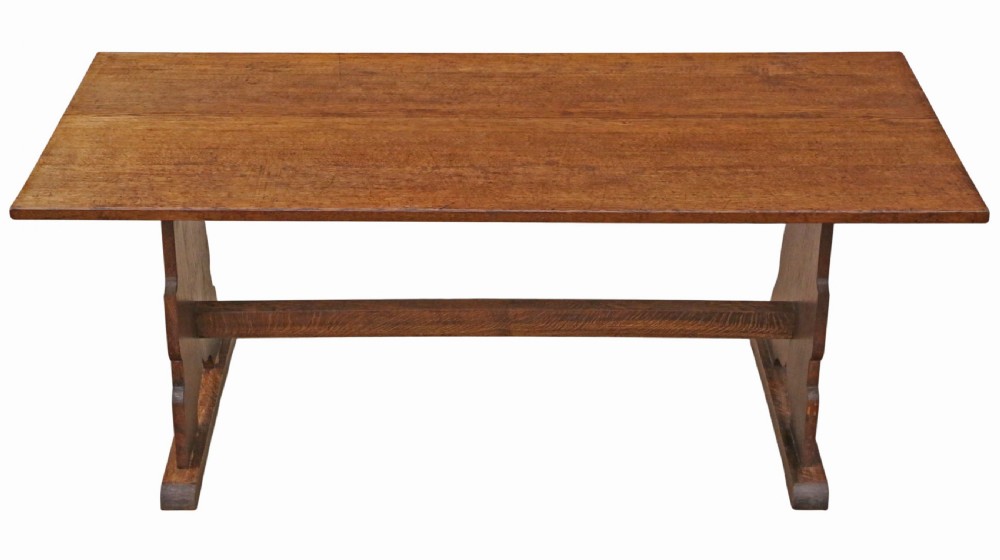 An antique late 19th-century solid oak Arts and Crafts refectory dining table featuring shaped trestle ends and a tusked tenon stretcher. View V