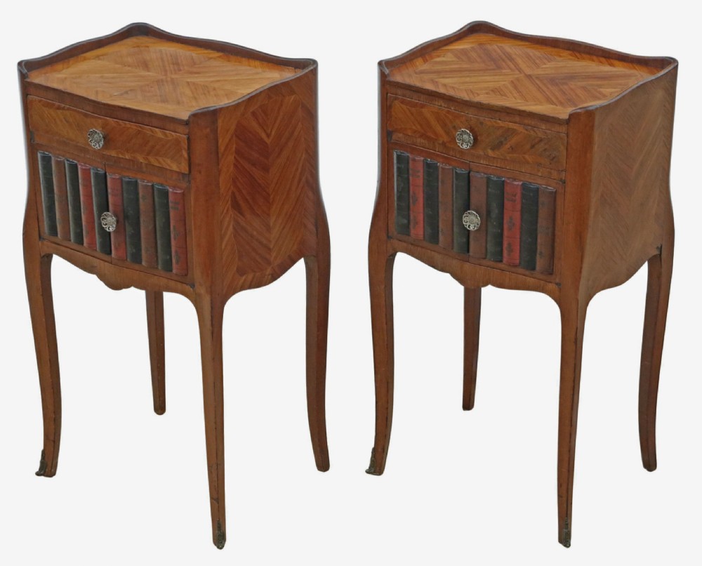A pair of French parquetry bedside tables featuring slender cabriole legs, a single top drawer, and a lower cabinet concealed by faux leather book spines.