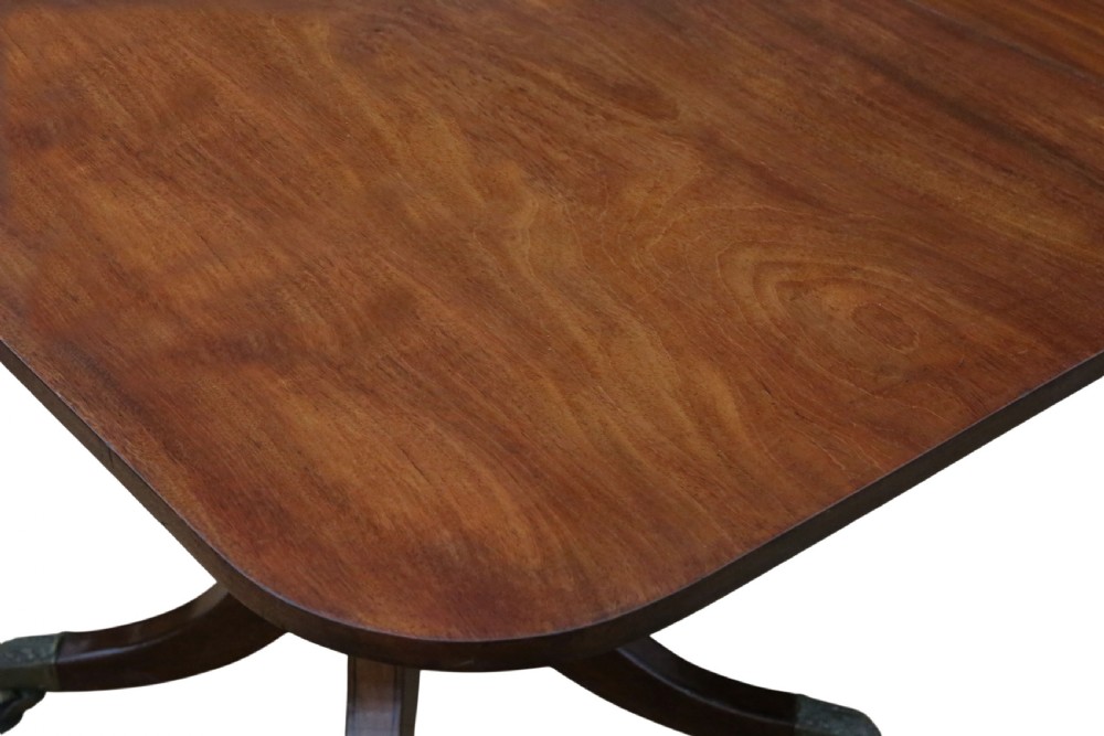 A 19th-century Georgian mahogany extending dining table set on twin pedestals with splayed legs and brass castors. View III