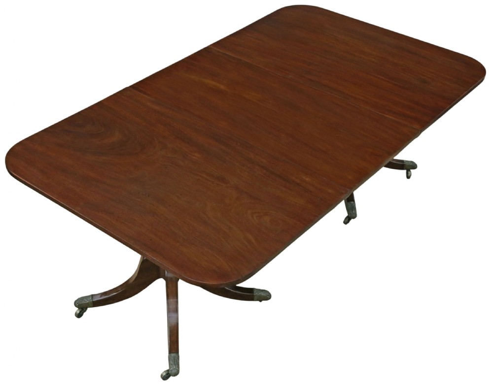 A 19th-century Georgian mahogany extending dining table set on twin pedestals with splayed legs and brass castors. View IV