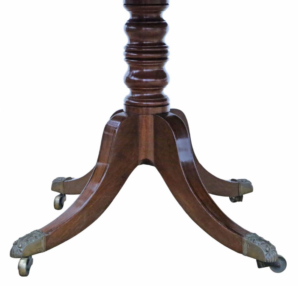 A 19th-century Georgian mahogany extending dining table set on twin pedestals with splayed legs and brass castors. View VII