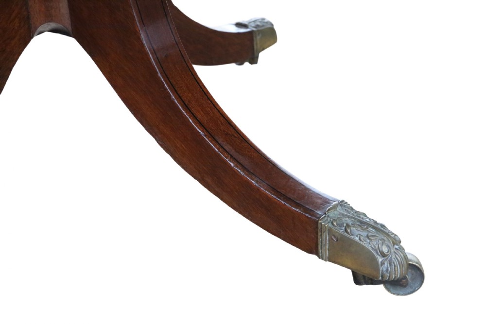 A 19th-century Georgian mahogany extending dining table set on twin pedestals with splayed legs and brass castors. View VIII