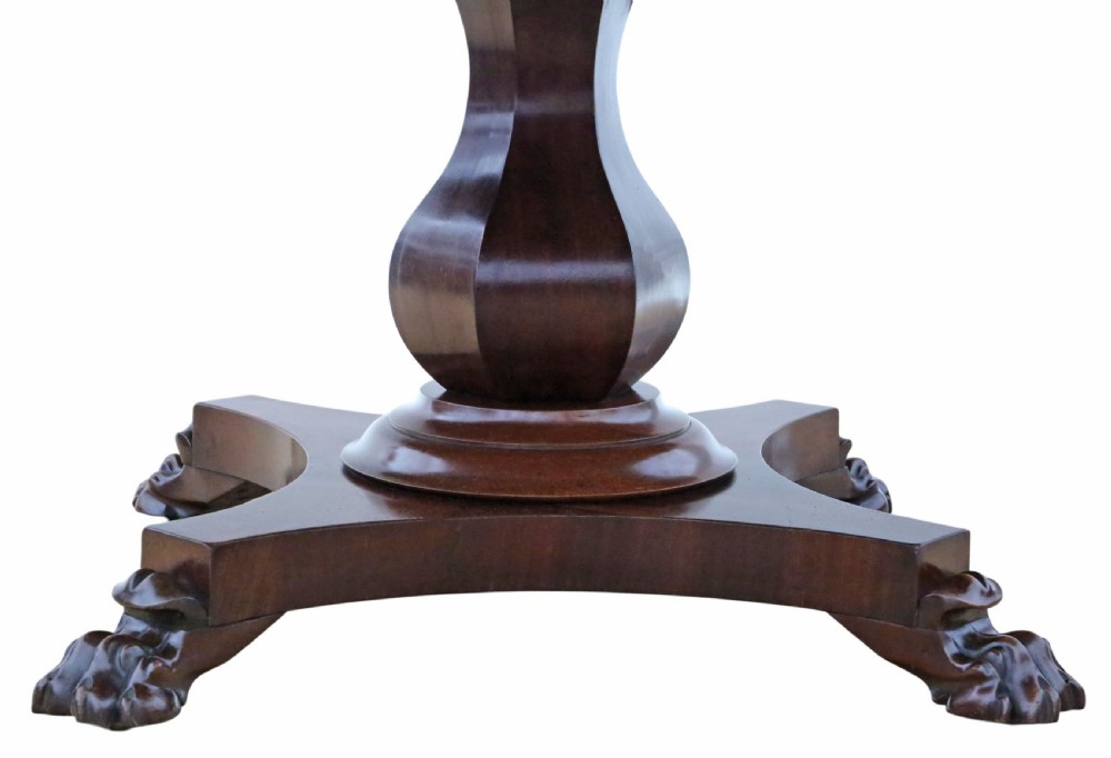 An antique nineteenth-century dark mahogany extending dining table featuring an oval top set on a central pedestal base with four carved paw feet. View III
