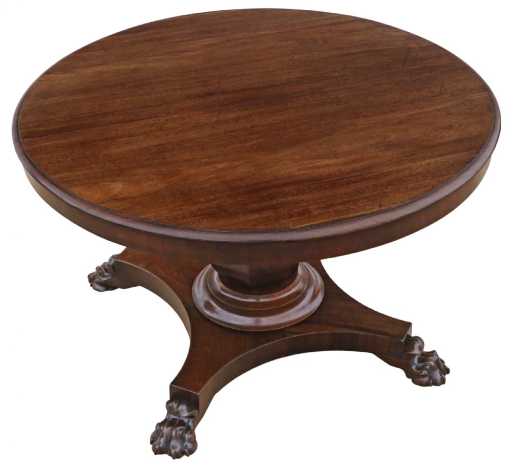 An antique nineteenth-century dark mahogany extending dining table featuring an oval top set on a central pedestal base with four carved paw feet. View VII