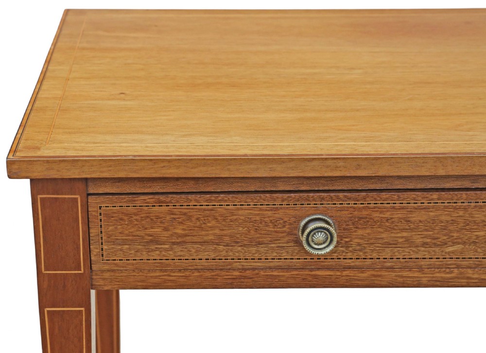 An Edwardian red walnut writing table with two drawers, decorative string inlay, brass ring handles, and tapered square legs. View IV