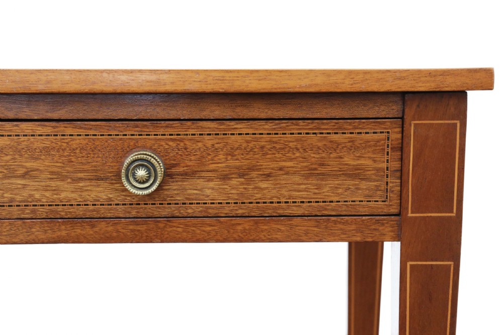 An Edwardian red walnut writing table with two drawers, decorative string inlay, brass ring handles, and tapered square legs. View VIII