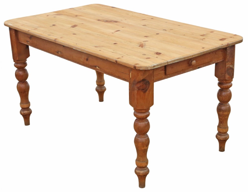 A 19th-century pine kitchen table featuring turned legs, a rectangular plank top, and an end drawer with a turned wood knob.