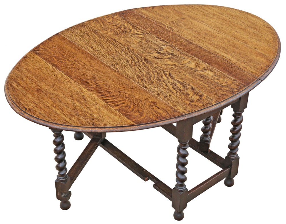 An oval oak drop-leaf dining table with barley twist turned legs and pivoting gateleg supports. View II