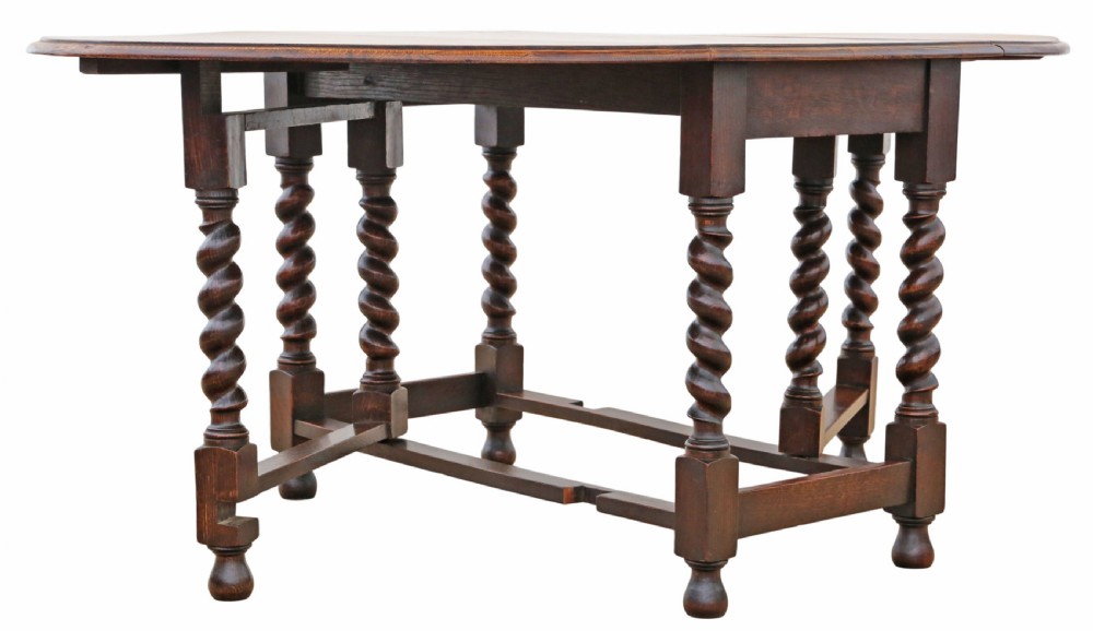An oval oak drop-leaf dining table with barley twist turned legs and pivoting gateleg supports. View III