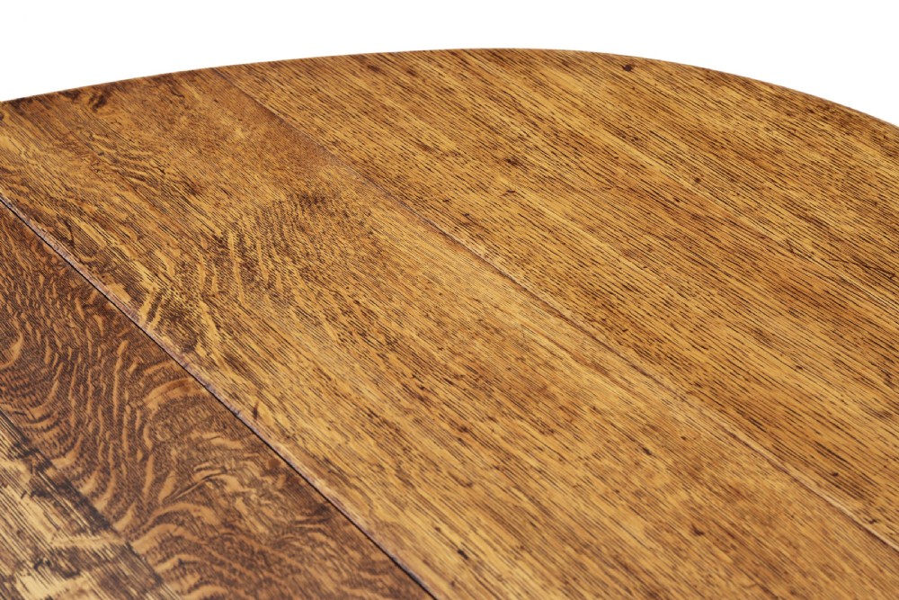 An oval oak drop-leaf dining table with barley twist turned legs and pivoting gateleg supports. View IV