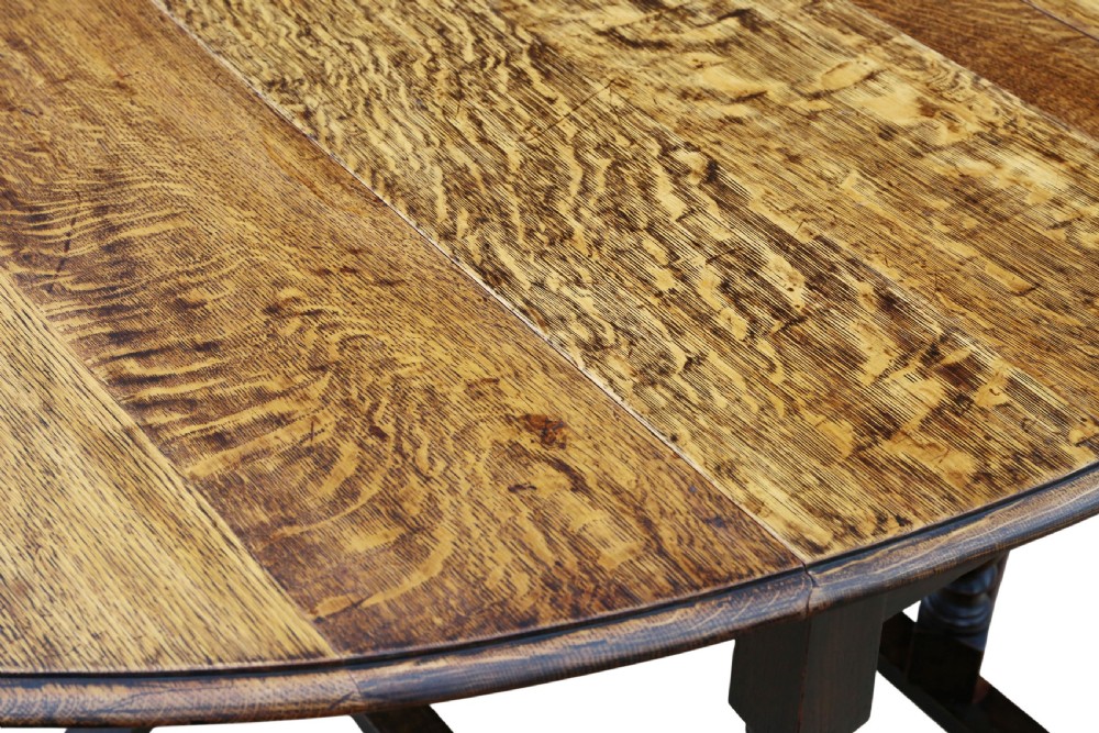 An oval oak drop-leaf dining table with barley twist turned legs and pivoting gateleg supports. View VII