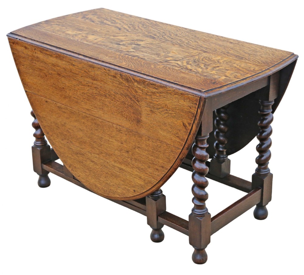 An oval oak drop-leaf dining table with barley twist turned legs and pivoting gateleg supports. View IX