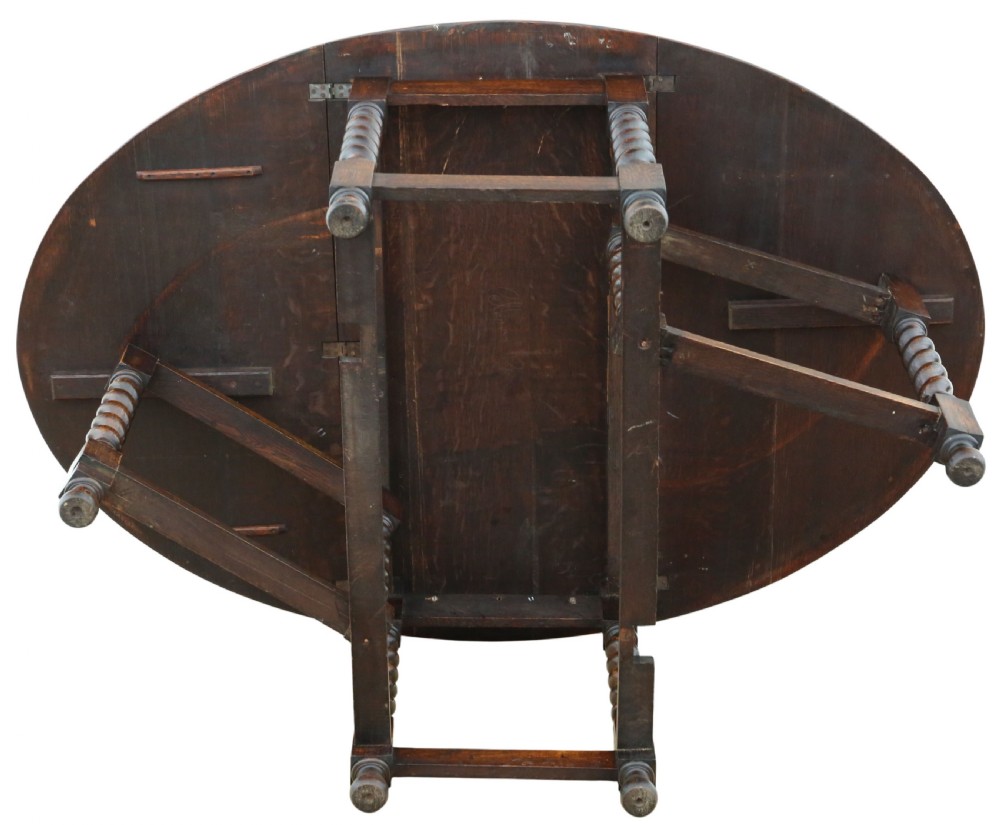 An oval oak drop-leaf dining table with barley twist turned legs and pivoting gateleg supports. View XI