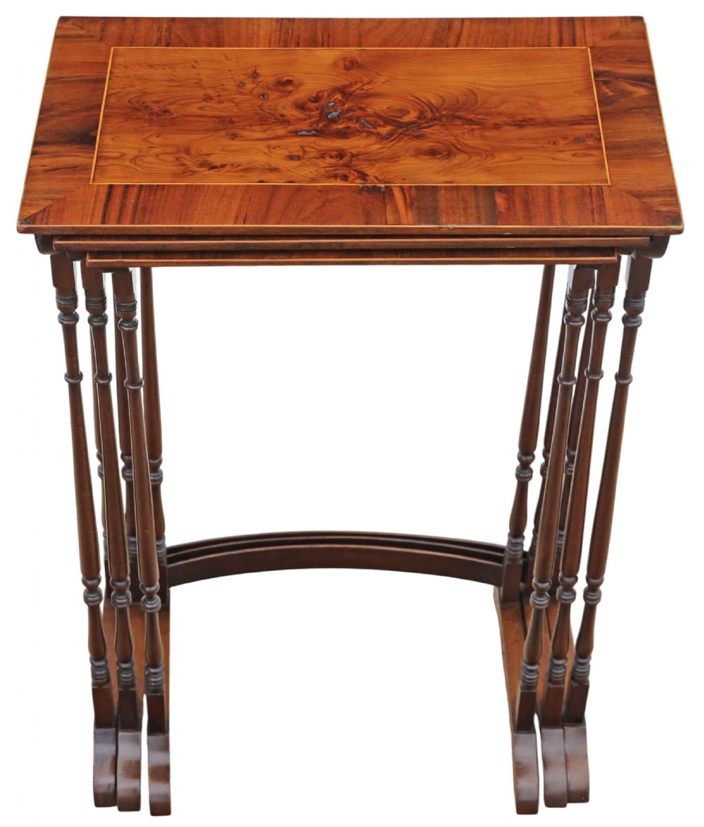 A set of three nested mahogany occasional tables featuring burr yew veneer tops with light wood inlay and slender turned legs. View III