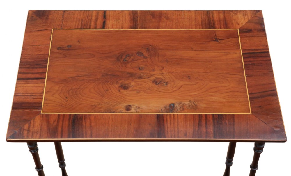 A set of three nested mahogany occasional tables featuring burr yew veneer tops with light wood inlay and slender turned legs. View V
