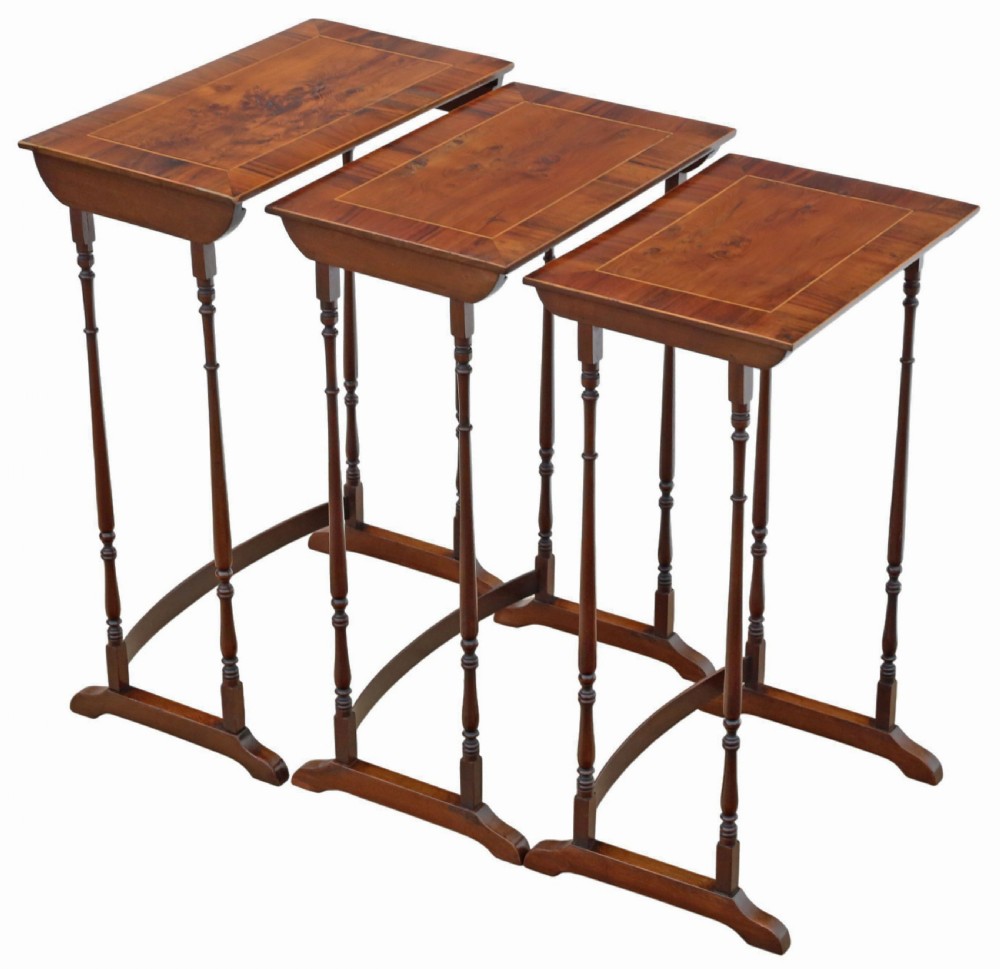 A set of three nested mahogany occasional tables featuring burr yew veneer tops with light wood inlay and slender turned legs. View VIII