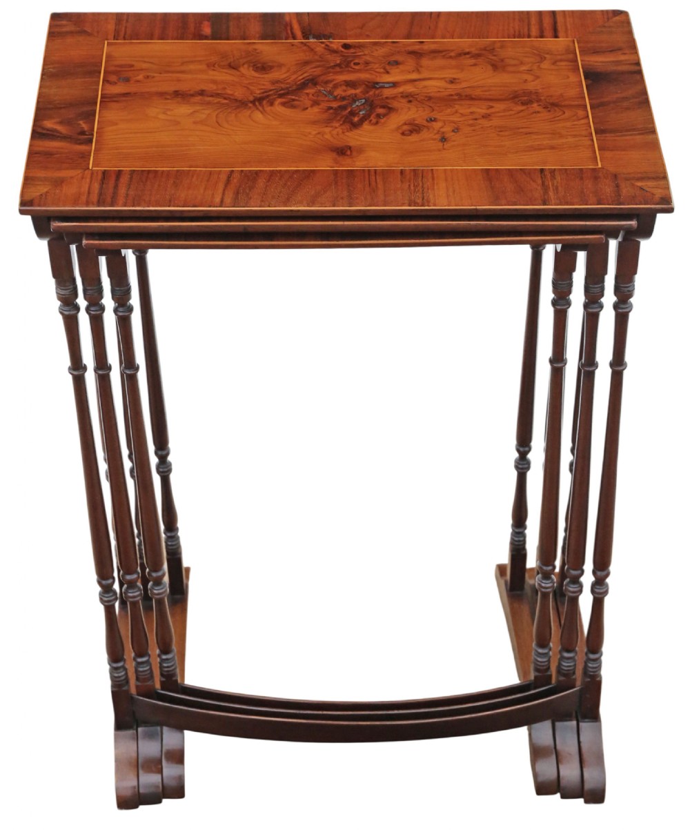A set of three nested mahogany occasional tables featuring burr yew veneer tops with light wood inlay and slender turned legs. View IX