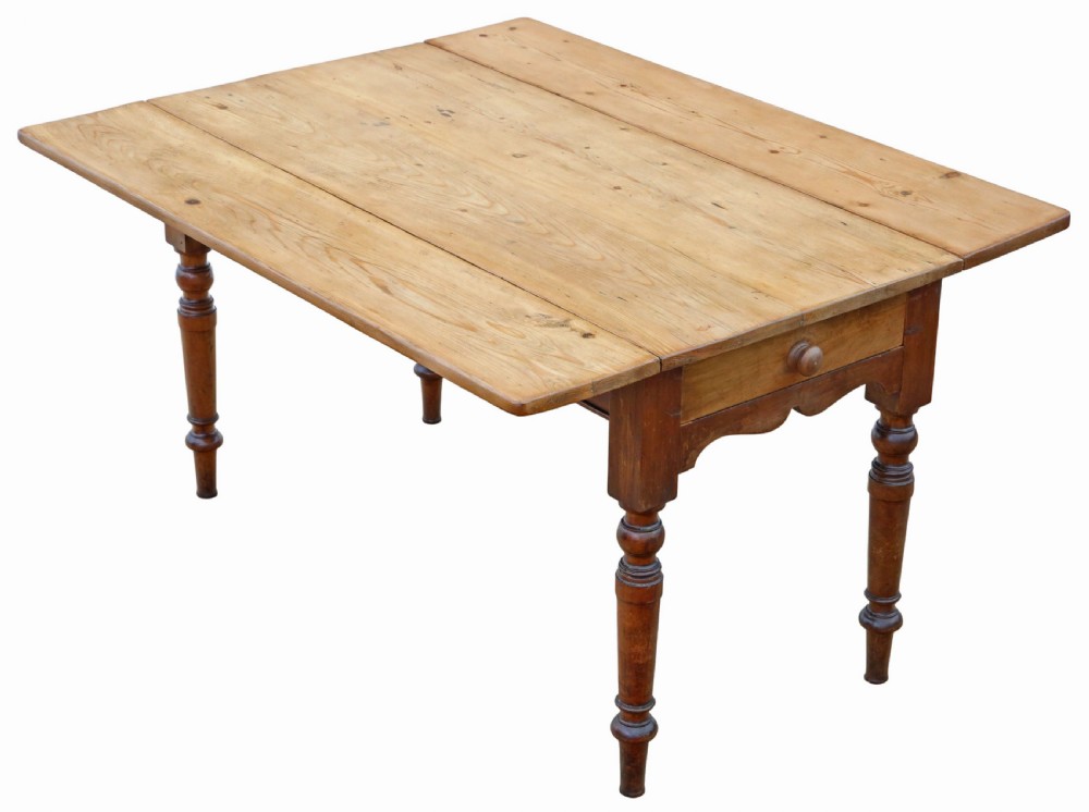 A 19th-century Victorian pine drop-leaf kitchen table featuring turned fruitwood legs, a single end drawer with a wooden knob, and a warm natural finish.