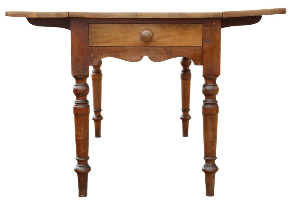 A 19th-century Victorian pine drop-leaf kitchen table featuring turned fruitwood legs, a single end drawer with a wooden knob, and a warm natural finish. View VI