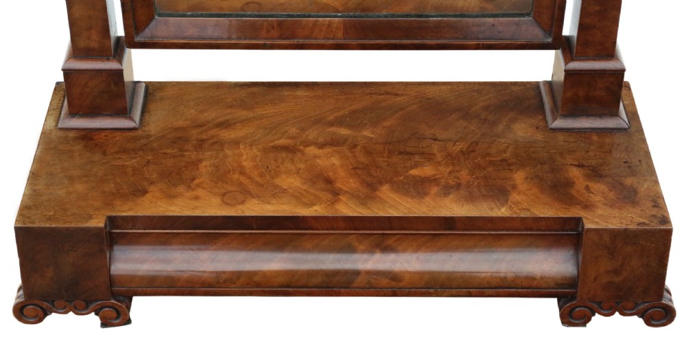 A nineteenth-century Regency mahogany dressing table mirror with a rectangular swivelling frame set between vertical posts on a plinth base with scroll feet. View V