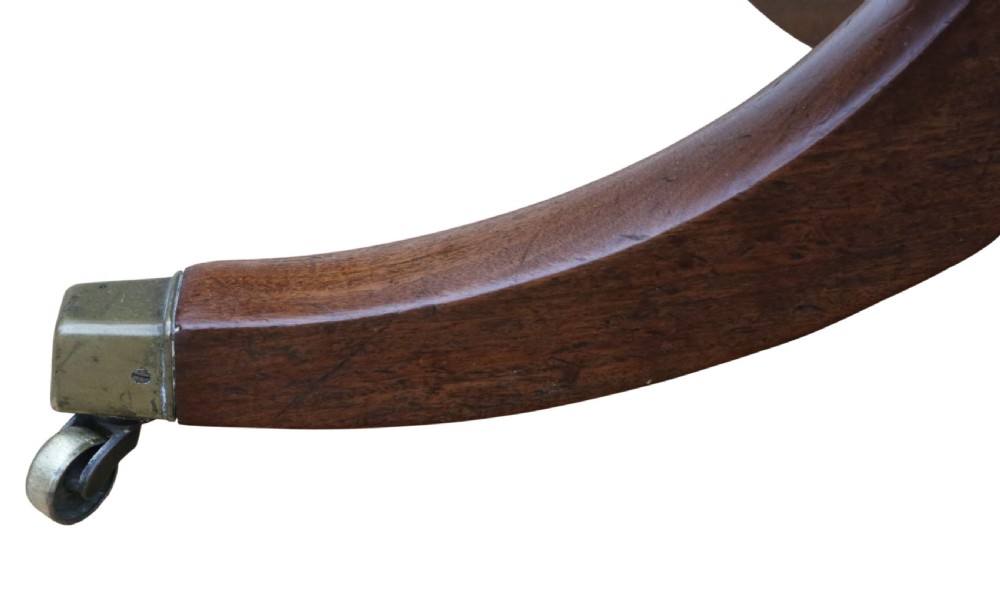 An early 19th-century Georgian mahogany twin pedestal dining table featuring turned columns, splayed legs, and brass cap castors. View V