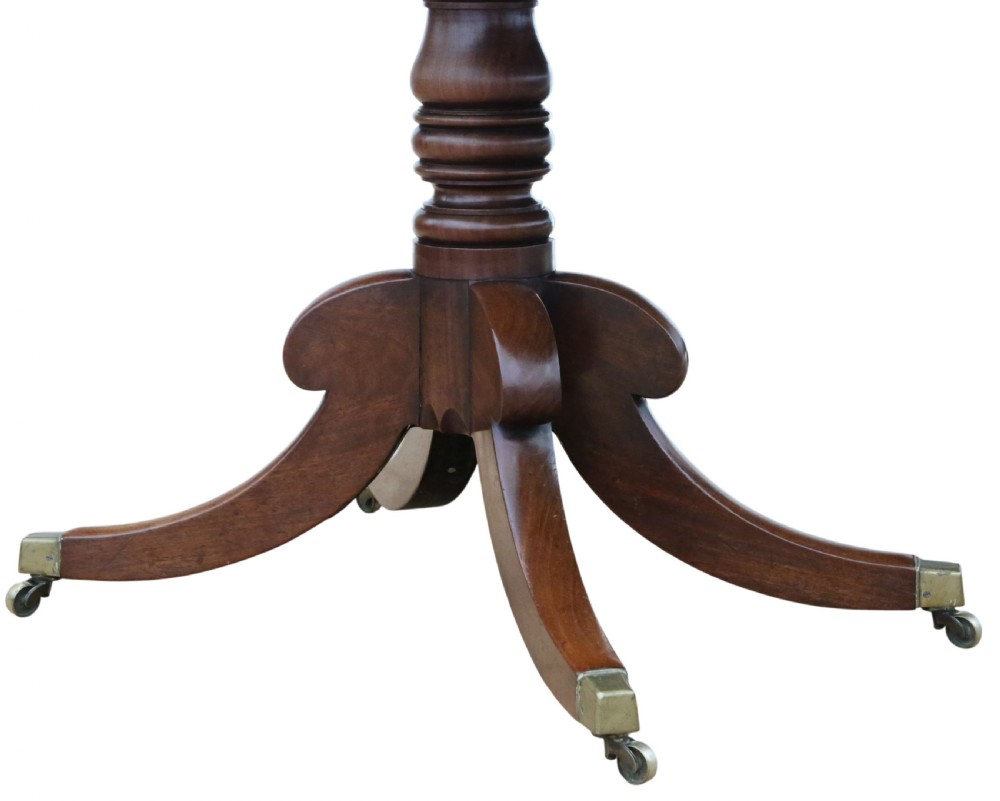 An early 19th-century Georgian mahogany twin pedestal dining table featuring turned columns, splayed legs, and brass cap castors. View VI