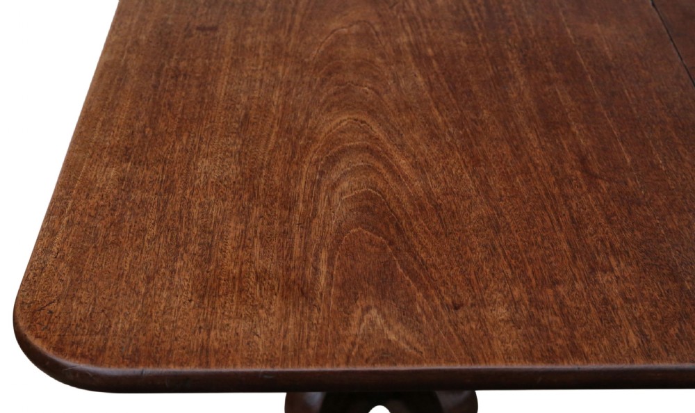 An early 19th-century Georgian mahogany twin pedestal dining table featuring turned columns, splayed legs, and brass cap castors. View IX