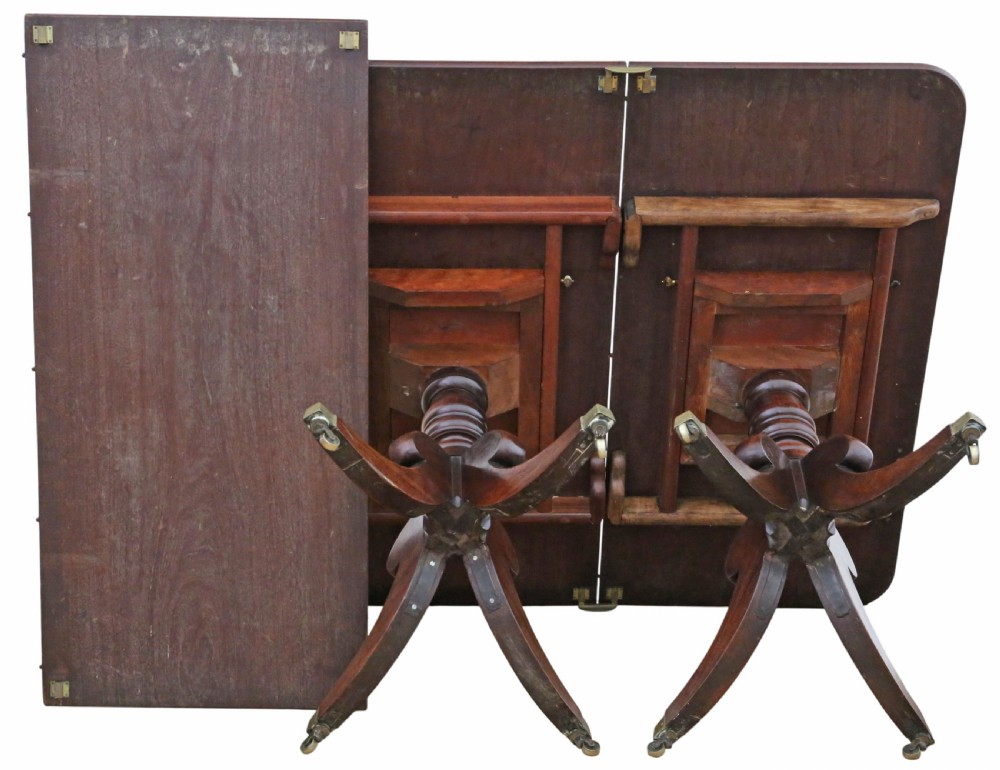 An early 19th-century Georgian mahogany twin pedestal dining table featuring turned columns, splayed legs, and brass cap castors. View XI
