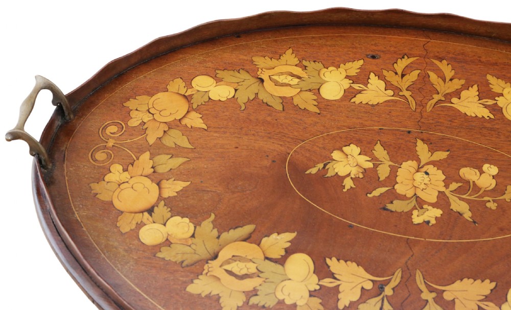 An oval mahogany serving tray featuring detailed floral marquetry inlay, a scalloped rim, and two cast brass handles. View II