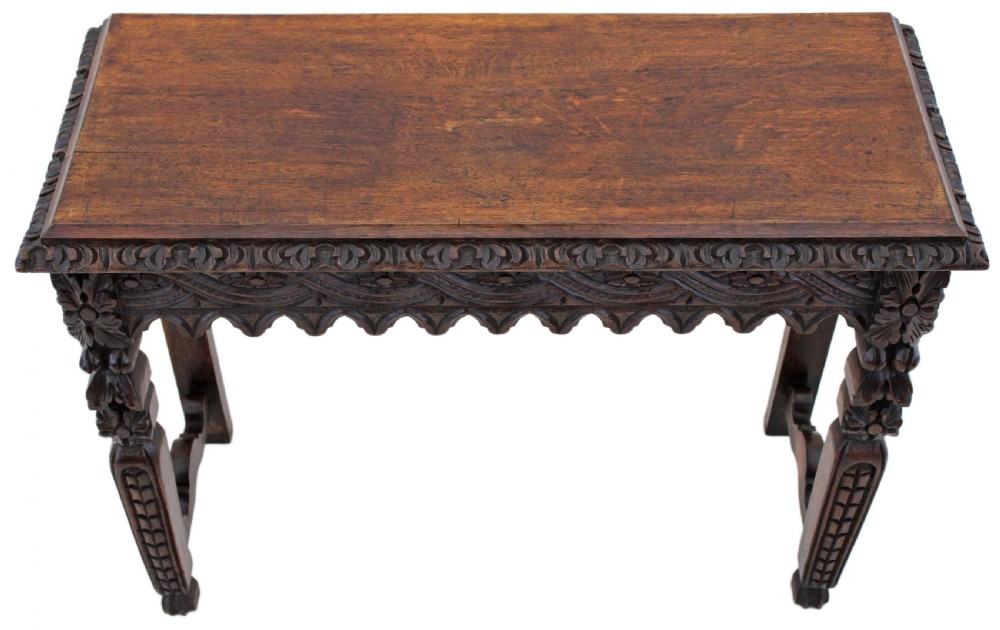 A 19th-century Victorian dark oak writing table featuring relief carving along the frieze, a scalloped apron, and carved end legs. View XIII