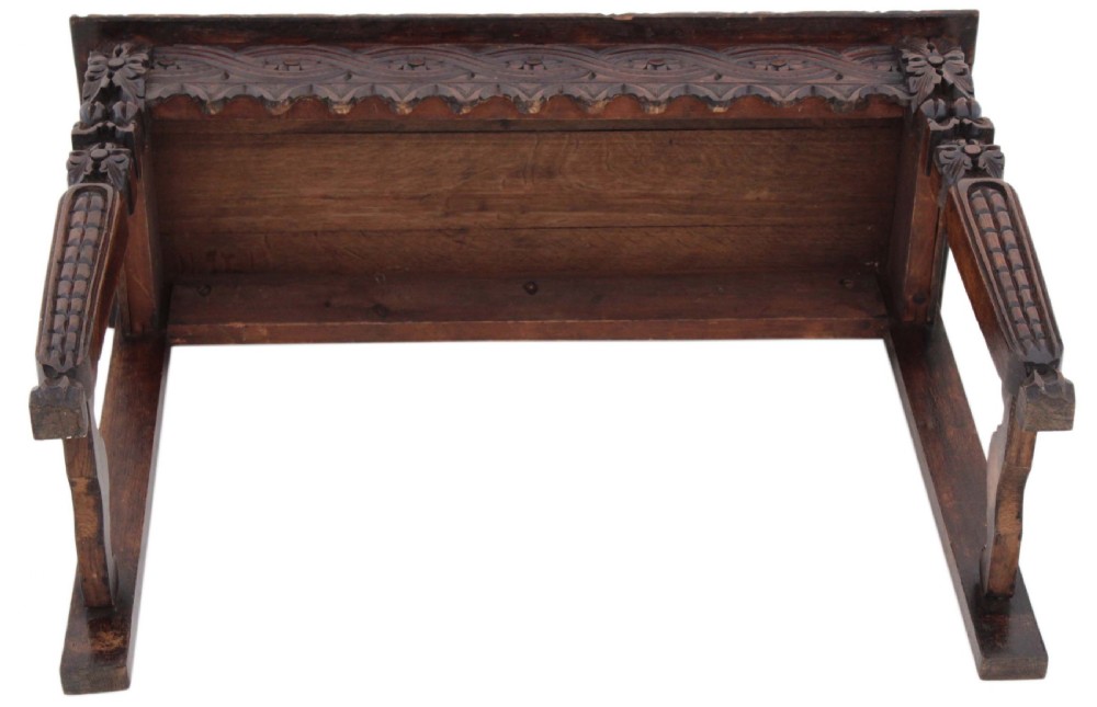 A 19th-century Victorian dark oak writing table featuring relief carving along the frieze, a scalloped apron, and carved end legs. View XV
