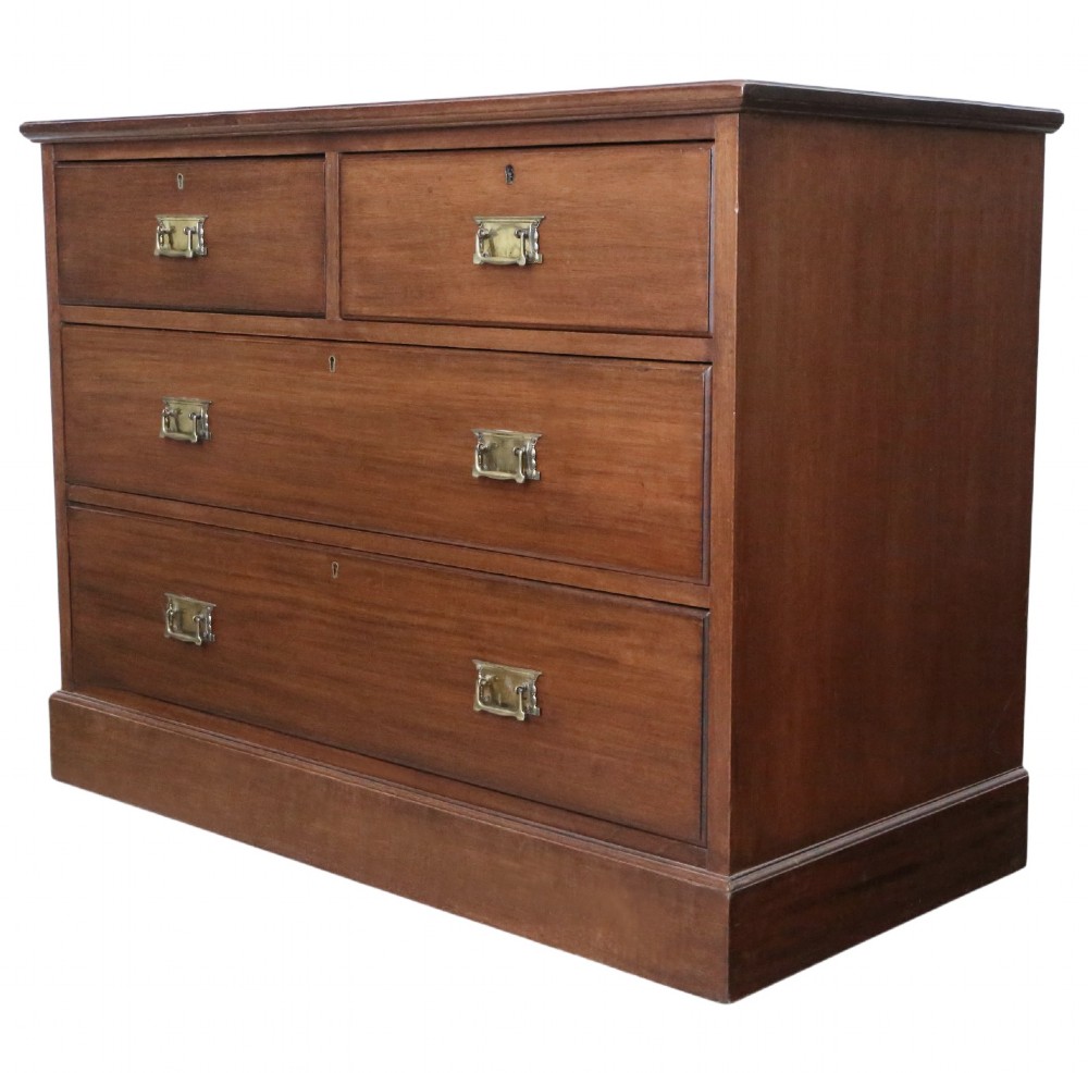 An Edwardian Art Nouveau mahogany chest of drawers featuring two short drawers above two long drawers with brass drop handles and keyhole escutcheons. View II