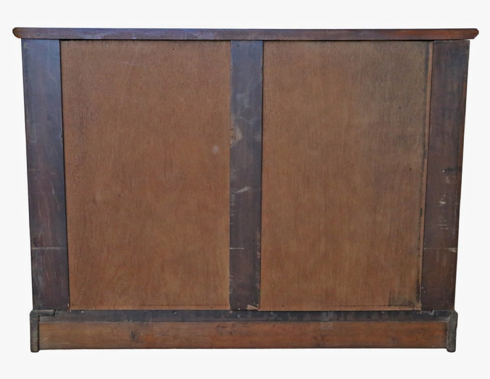 An Edwardian Art Nouveau mahogany chest of drawers featuring two short drawers above two long drawers with brass drop handles and keyhole escutcheons. View VI