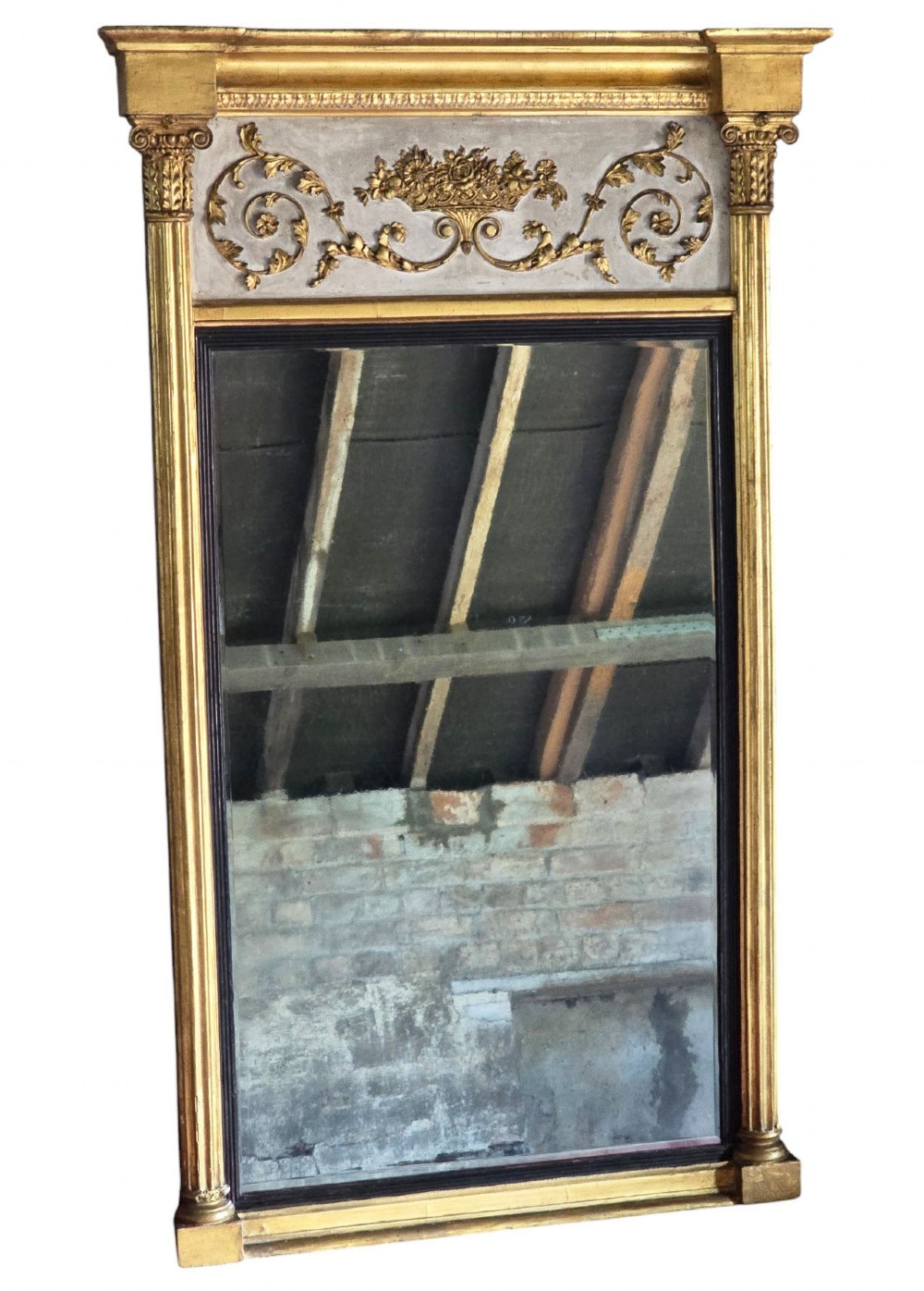 A tall 19th-century neoclassical overmantel pier mirror featuring a gilt frame, fluted side pilasters, and an upper floral frieze panel.
