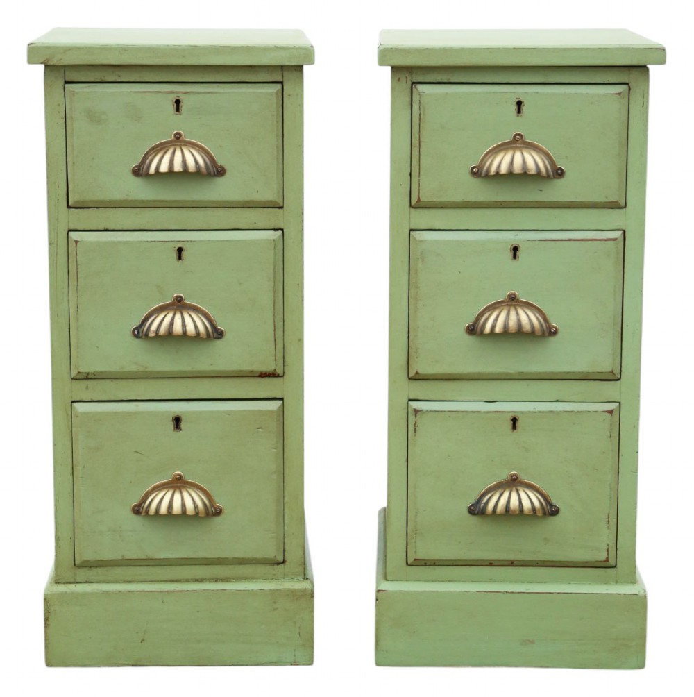 A pair of matching narrow green-painted wooden bedside cabinets, each featuring three drawers with brass shell cup handles and a solid plinth base.