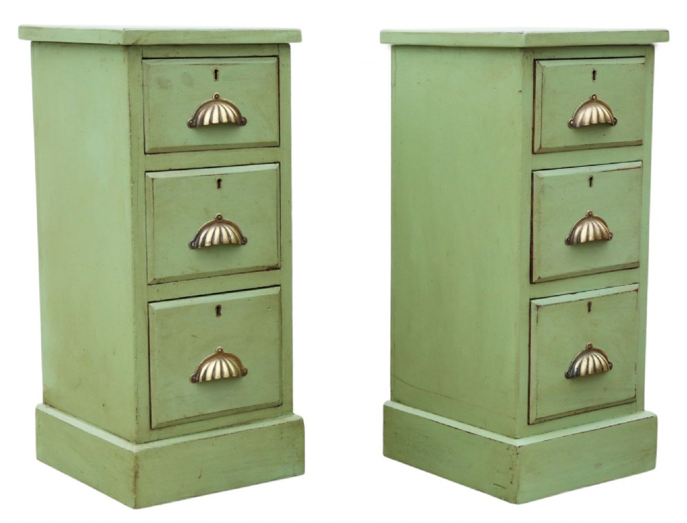 A pair of matching narrow green-painted wooden bedside cabinets, each featuring three drawers with brass shell cup handles and a solid plinth base. View VI