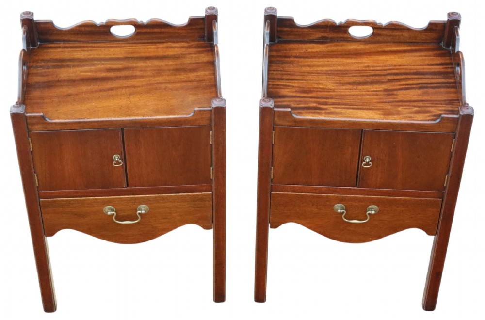 A matching pair of warm brown mahogany bedside cupboards with tray tops, double door compartments, lower drawers, and brass handles. View II