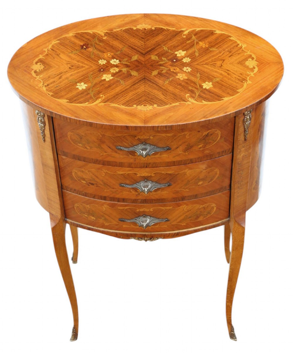 A pair of French oval bedside tables with floral marquetry inlay, three drawers, gilt mounts, and slender cabriole legs. View VI