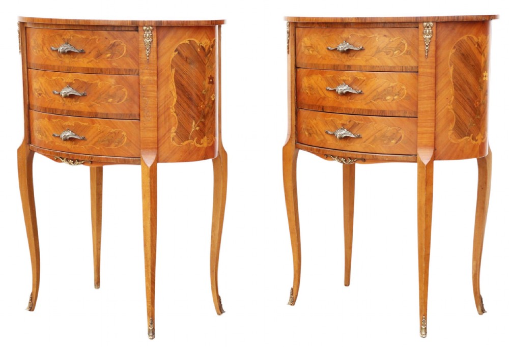 A pair of French oval bedside tables with floral marquetry inlay, three drawers, gilt mounts, and slender cabriole legs. View VII