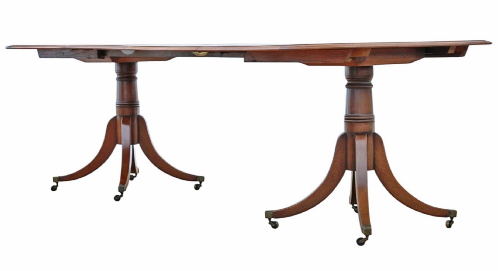 A 19th-century mahogany twin pedestal extending dining table with rounded corners, reeded edge detailing, and brass castors. View III