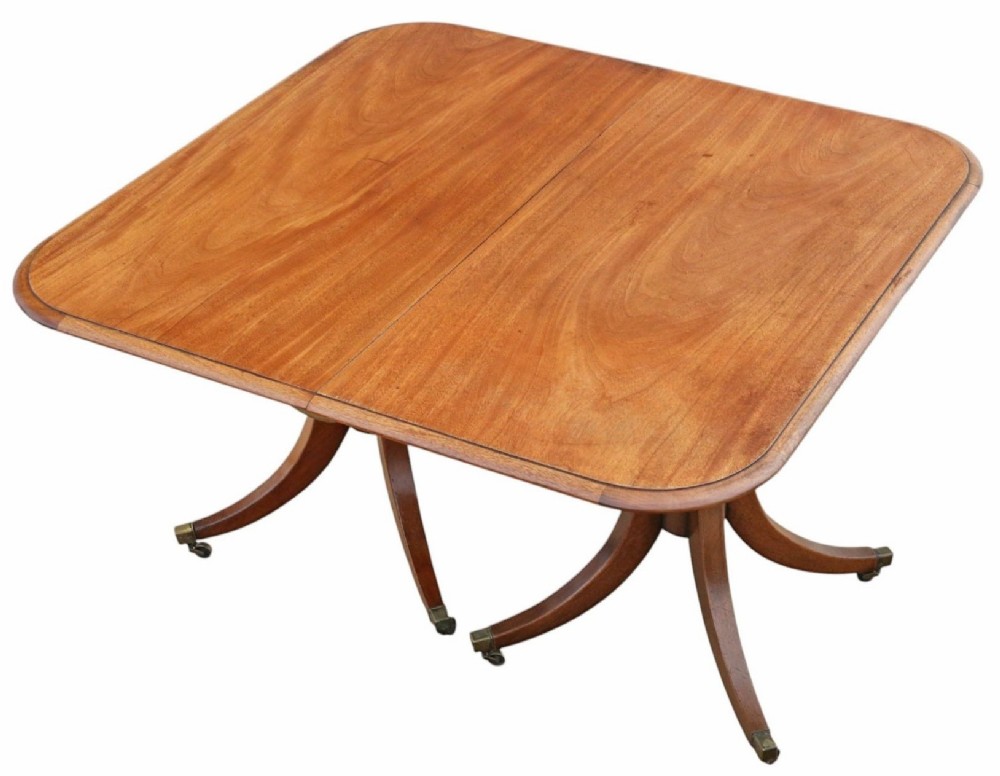 A 19th-century mahogany twin pedestal extending dining table with rounded corners, reeded edge detailing, and brass castors. View X
