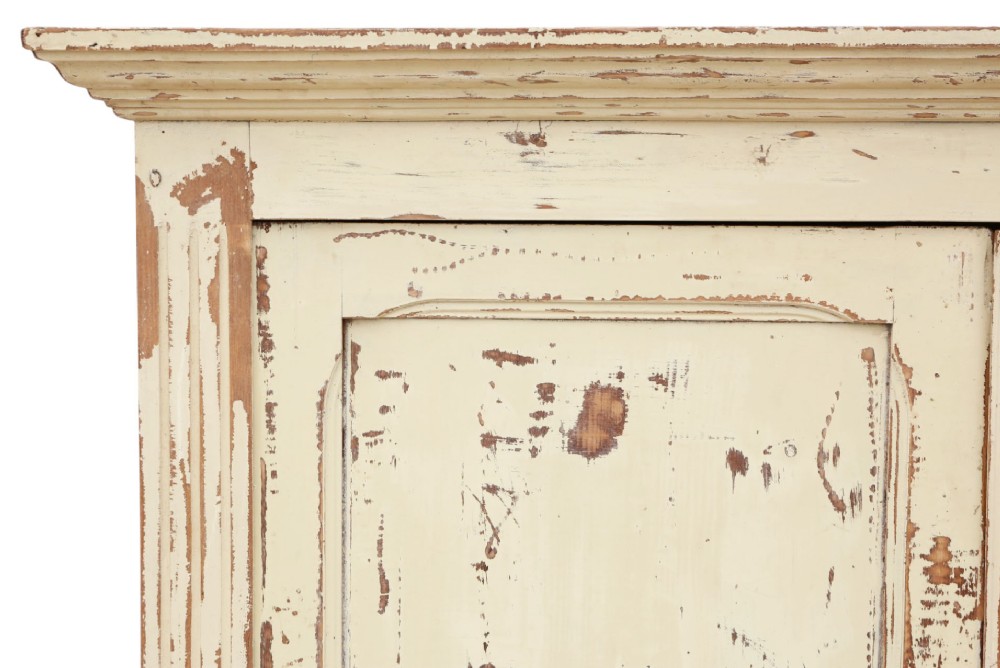 A 19th-century two-tier wooden storage cupboard painted in distressed cream, featuring fluted side details, upper and lower double doors with fielded panels, and two central drawers. View VII