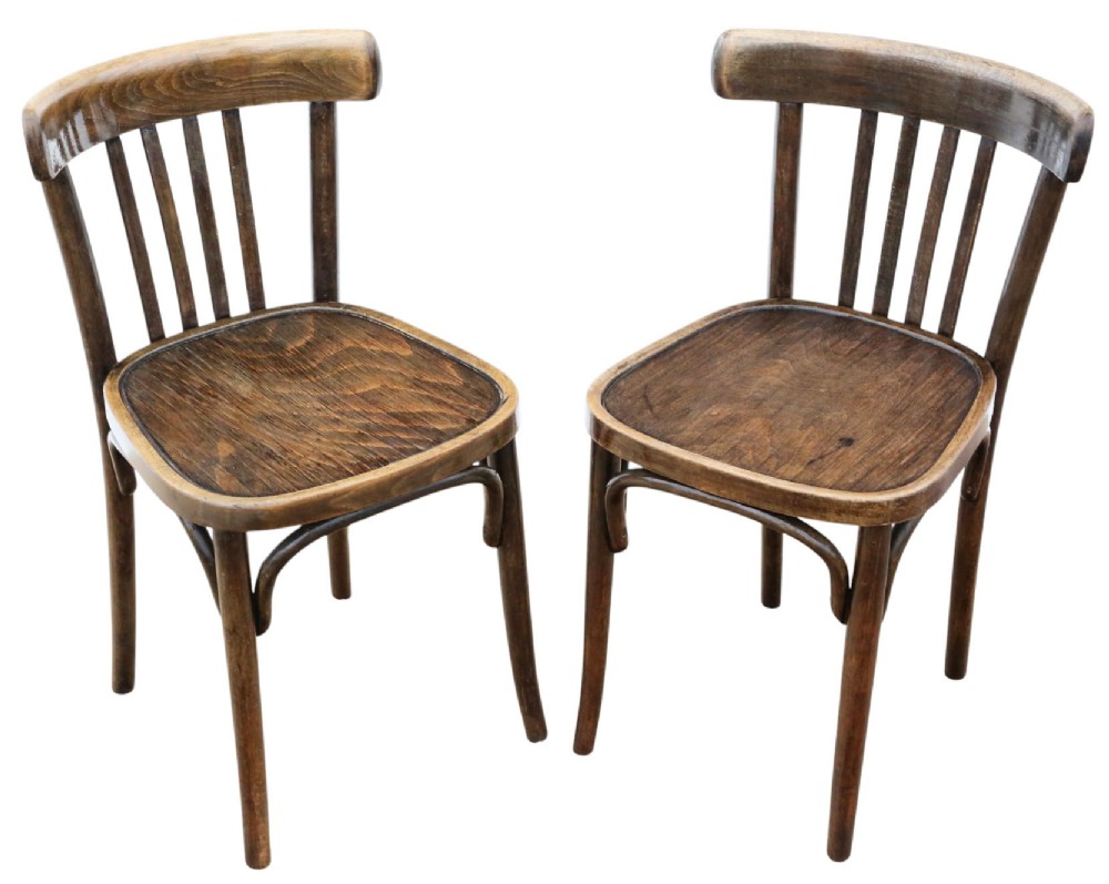 A pair of dark brown bentwood bistro dining chairs featuring vertical back spindles, steam-bent frames, and contoured wood seats.