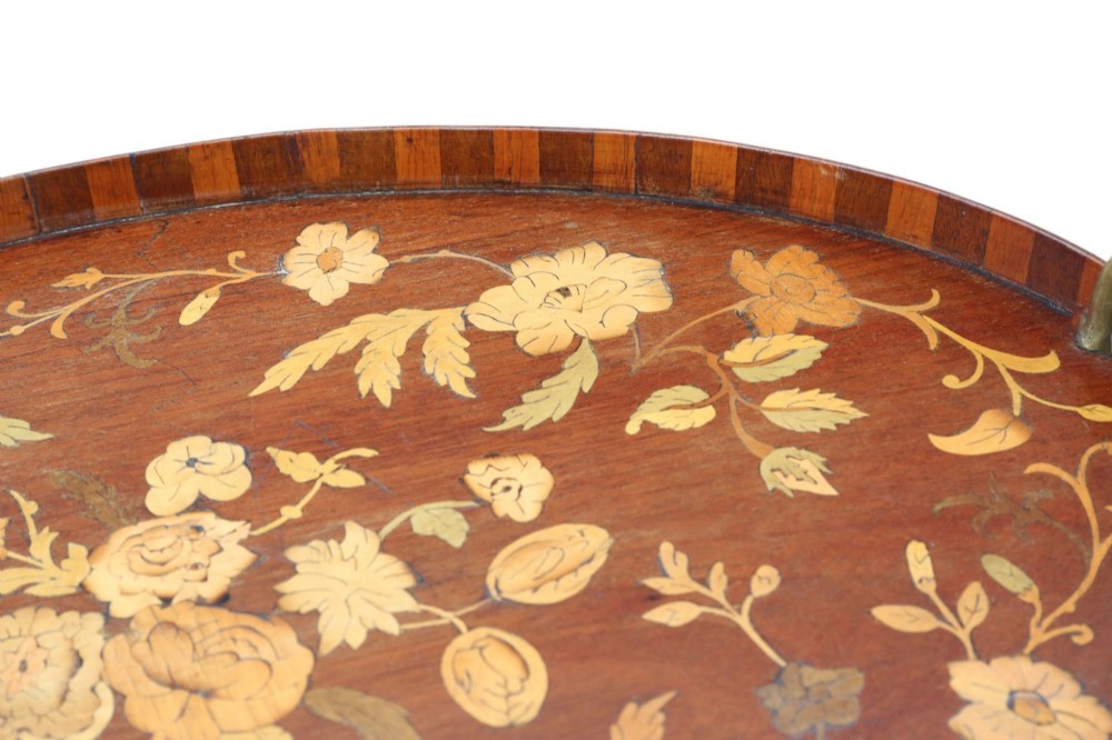An oval mahogany serving tray decorated with floral marquetry inlay and fitted with twin brass handles. View III