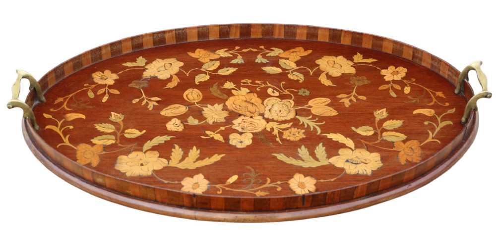 An oval mahogany serving tray decorated with floral marquetry inlay and fitted with twin brass handles. View IV