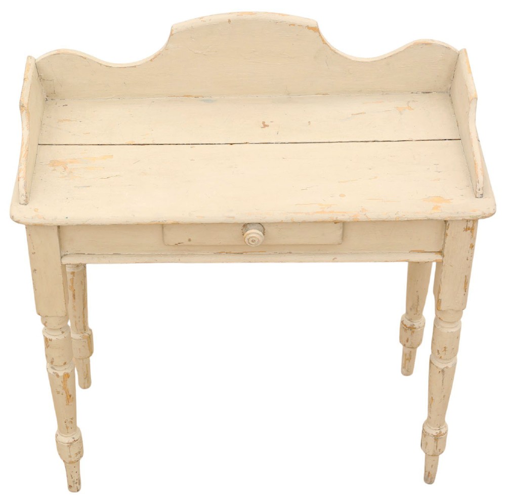 A 19th-century cream painted wooden writing table featuring a shaped gallery back, turned legs, and a single central drawer with a turned wooden knob. View V